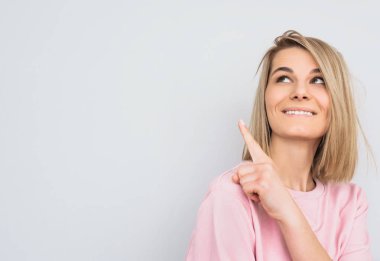 Mutlu sarı saçlı kadın giyer pembe kazak gösterir ile portre portre baş parmak, arama bir yana, bir şey boş kopya alanı reklam için de gösterir. İnsanlar ve duygu kavramı