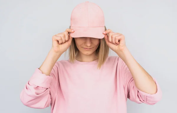 커버와 분홍색 스웨터를 분홍색 모자와 그녀의 화이트 스튜디오 배경에 광선에서 스톡 사진