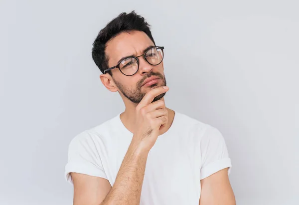 Beyaz T-shirt giyen düşünceli sakallı adam portresi görünüyor ikindilerde bir yana, onun eylem ve yeni projeler, beyaz stüdyo duvar arka plan üzerinde poz için planları hakkında düşünüyor. İnsanlar ve duygu kavramı