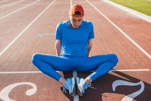 Atlet Kaukasia Sportif Melakukan Latihan Peregangan Duduk Lintasan Lari Laki — Stok Foto