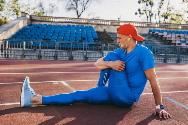 Tiro Horizontal Atleta Atractivo Joven Macho Estirando Pierna Una Pista — Foto de Stock