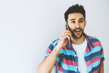 Kullanarak ve cep telefonu üzerinde konuşurken Kafkas yakışıklı adam portresi sorunlu ve şaşırttı. İnsan duyguları, ifadeleri ve tutum. Aygıtla iletişim için işadamı dert. Teknoloji.