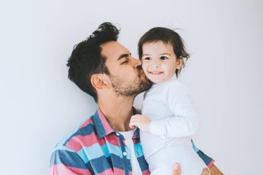 Bir hipster baba küçük kızı öpüşme portre çekici yakından. Genç Baba zaman onun çocuğuna keyif alıyor. Küçük kız yakışıklı babasıyla. Mutlu baba ve kızı. Yaşam tarzı aile.