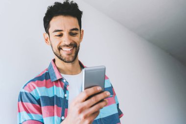 Beyaz kopyalama boşluk duvar bilgin karşı poz gömlek, cep telefonu, manifatura mutlu beyaz adam. Teknoloji ve bağlantı. Yaşam tarzı kavramı. Yakışıklı erkek gülümseme aygıt ile.