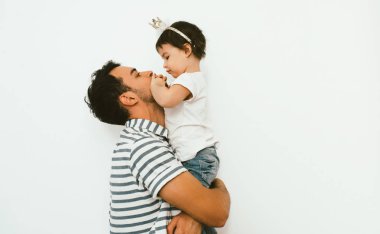 Mutlu baba ve güzel kızı yan görünüm oynamak ve birlikte beyaz arka planı kucaklamak. Aile sevgi ilişkisi. Baba ve yürümeye başlayan çocuk kızın Doğum günü iyi eğlenceler.