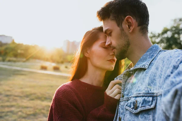 Fashion romantic traveling couple making selfie on park background, attractive sunlight, carefree mood. Caucasian man and woman embracing together at date day on naure backgroud. Lifestyle concept.