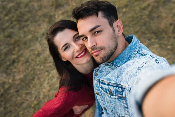 Two happy lovers people enjoying they date, embracing each other, making selfie  outdoor with love having eyes full of happiness. Attractive couple making self-portrait on dating day. Family portrait.
