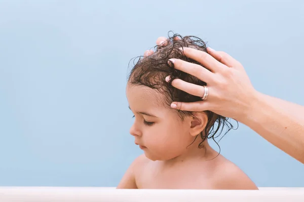 귀여운 목욕입니다 어머니는 그녀의 아이에 머리를 세척입니다 욕조에 파란색 배경에 — 스톡 사진
