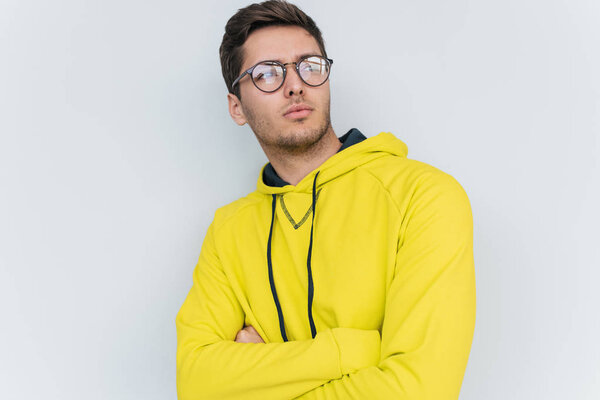 portrait of man wearing yellow hoodie and trendy glasses