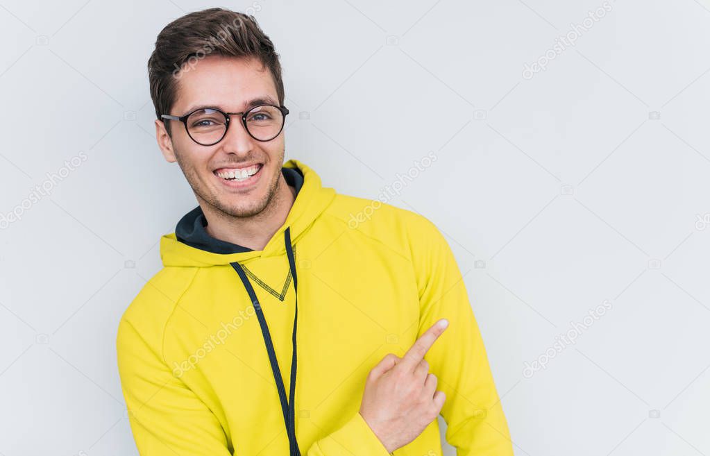 Portrait of young male model wearing trendy glasses and looking at camera 