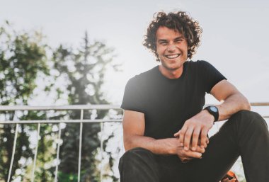 Düşük görünümü atış mutlu şık genç adamın siyah t-shirt ve wirstwatch sokakta giyer. Mutlu gülümseyen adam poz için reklam kopya alanı, şehrin sokak açık ile. İnsanlar kavramı