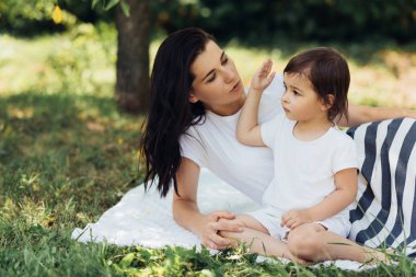Samimi bir kadeh neşeli anne ve açık havada oynarken, konuşurken ve şarkı sevimli kızı. Annem ile birlikte parkta oynayan güzel çocuğu. İyi ilişki içinde aile portresi. 