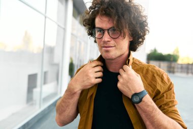 Mutlu genç hipster adam stundent açık portresi gömlek ve sokakta yürürken wirstwatch giyer. Akıllı erkek poz dışında şehir. Alan metni kopyalayın. Kişi ve iş kavramı