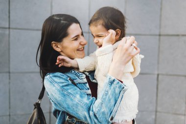 Mutlu güzel anne ve bebek kız şehir sokak yürüyüş ve birlikte oynamak. Üst ve alt iyi ilişkisi. Anne ve yürümeye başlayan çocuk mutlu aile anları. Çocukluk ve annelik Bakımı.
