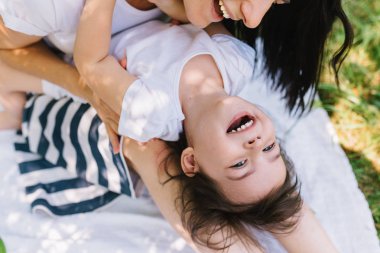 Yatay atış mutlu çocuk kızı ve açık oynayan güzel annesi kırpılmış. Şirin anne ve çocuk parkta birlikte oynar. Yakın çekim mutlu bir aile portresi. Mutlu anneler günü.
