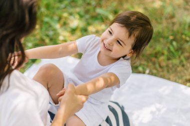 Gülümseyen küçük sevimli kız çocuk mutlu görünümünü kırpılmış yan açık havada parkta iyi tatiller beraber eğlenelim anne. Anne ve çocuk iyi bir ilişki. Mutlu anneler günü. Mutlu çocukluk kavramı