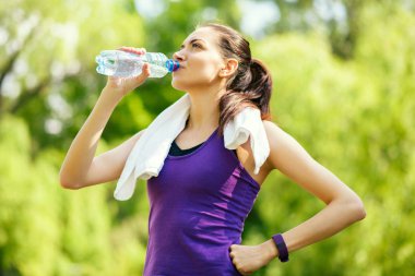 Duraklat. Eğlence genç çekici sportif kadın içme suyu doğa, park, orman arka plan üzerinde. Spor