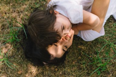 En iyi görünümü açık oynayan kız gülümseyerek onu eğlenceli ve güzel mutlu anne. Şirin anne ve birlikte parkta oynarken onun çocuk. Mutlu aile portresi. Annelik.