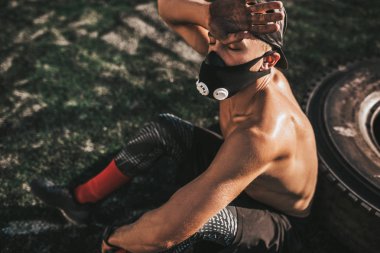 Kaslı erkek maskeli kasları lastik-flip egzersiz açık havada yaparak sabah sırasında nefes üzerinde artırmakta kadeh kırpılmış. Uzay kopyalayın. Gömleksiz sporcu egzersiz yapıyor 