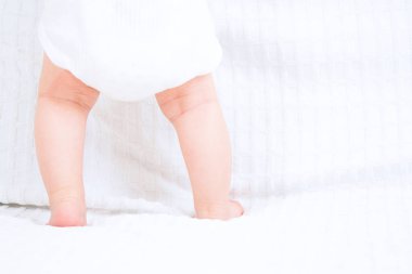 Beyaz arka plan üzerinde duran bebek düşük bölümü. Bebek ayak.