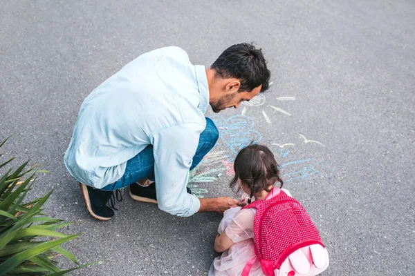 小さな女の子とお父さんの歩道にチョークで図面の平面図イメージ 一緒に公園で彼のかわいい子供は屋外のハンサムな男性プレイ 関係が大好きです 父と子の活動教育 — ストック写真