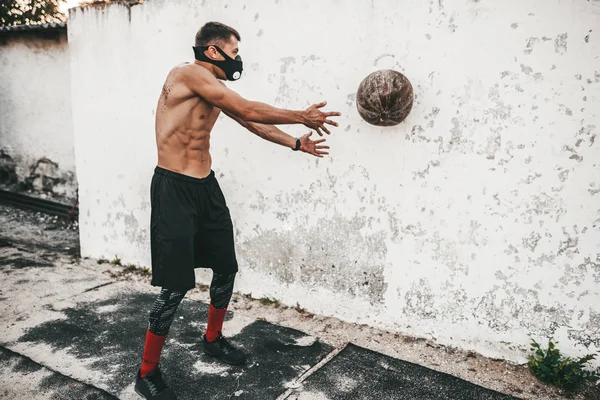 Horizontal Image Muscular Male Doing Exercises Medicine Ball Mask Concrete — Stock Photo, Image