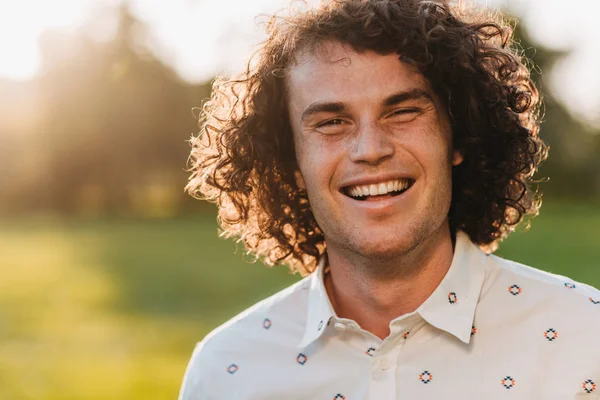 Jovem Caucasiano Feliz Com Cabelo Encaracolado Sorrindo Ensolarado Parque Olhando — Fotografia de Stock