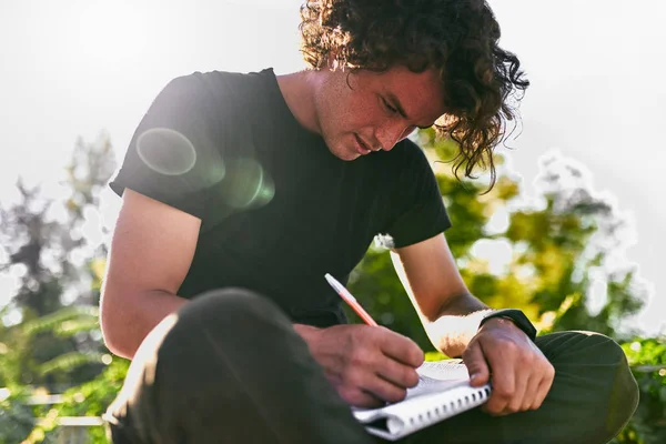 Image Plein Air Bel Étudiant Masculin Aux Cheveux Bouclés Écrivant — Photo