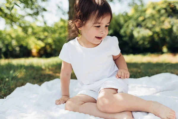 여자의 담요에 공원에서 재미가 아동의 긍정적인 식입니다 햇빛에 귀여운 꼬마입니다 — 스톡 사진