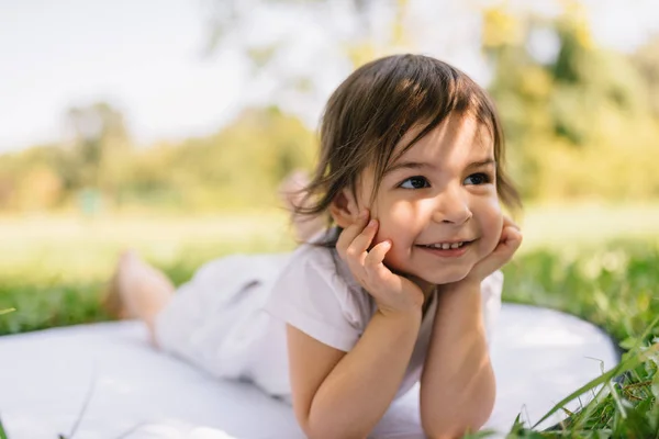 Οριζόντια Εικόνα Του Ένα Χαμογελαστό Χαριτωμένο Μικρό Κορίτσι Ξαπλωμένο Στο — Φωτογραφία Αρχείου