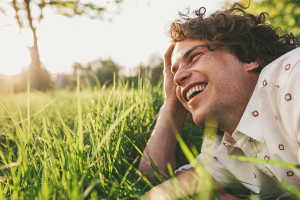 Happy Caucasian Young Man Curly Hair Smiling Lying Green Grass — Stock Photo, Image