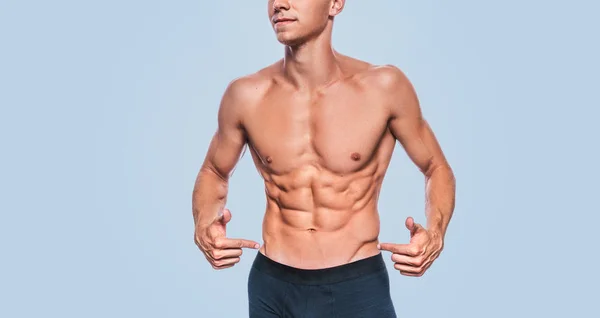 Horizontal studio image of fitness muscular male model in black underwear showing his abdominal press on a blue background. Cropped head portrait of sporty healthy strong athletic man with sexy torso. — Stock Image Horizontal Studio Image Fitness Muscular Male Model Black Underwear Showing Stock Picture