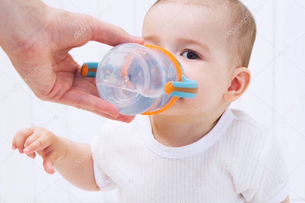 Beautiful baby drinking water from bottle