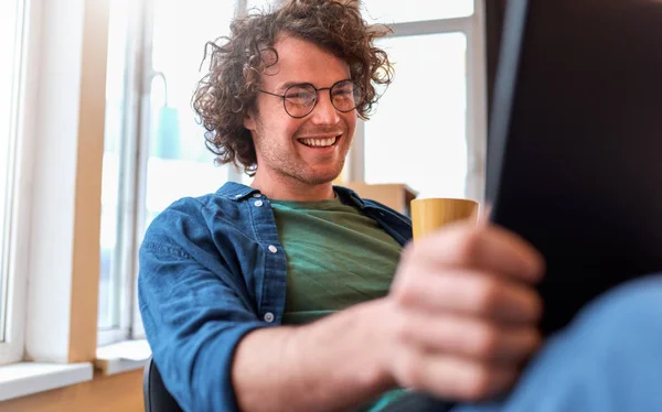Молодий Підприємець Сидить Офісі Розмовляючи Мобільному Телефоні Працюючи Ноутбуці Усміхнений — стокове фото