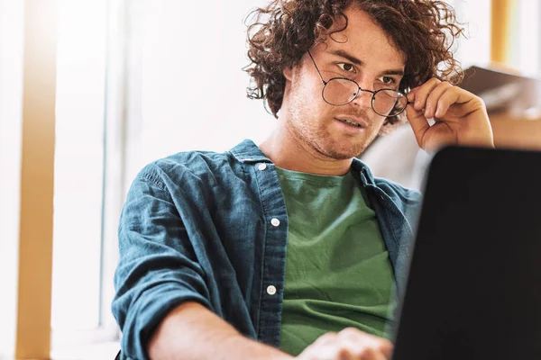 Shot Young Man Curly Hair Sitting Table Looking Laptop Thinking — Stock Photo, Image