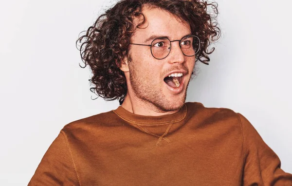 Studio closeup portrait of excited successful male student or employee with curly hair screaming with winning expression, posing on white studio background. Copy space. People and emotions concept — Stock Photo, Image