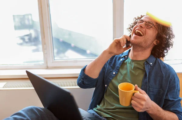 Positive Young Man Curly Hair Sitting Office Talking Mobile Phone — Stock Photo, Image