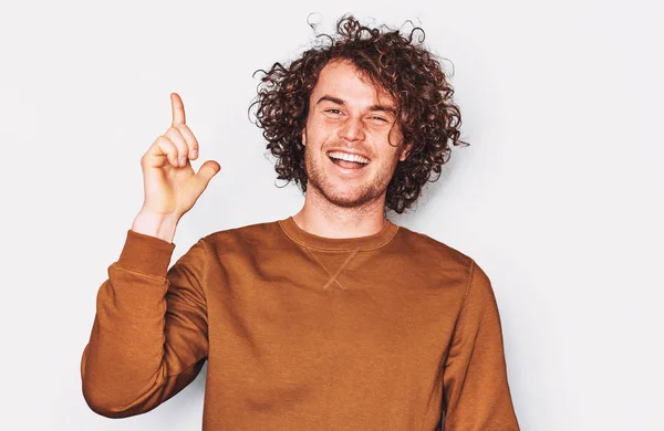 Confident Young Male Wears Brown Pullover Indicates Fore Finger Smiling — Stock Photo, Image