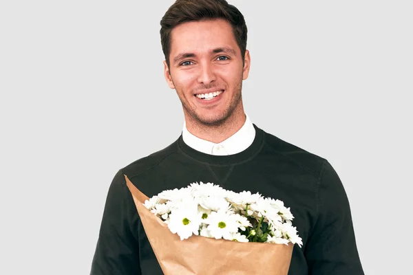 Портрет счастливого красивого мужчины, улыбающегося, дарящего букет белых цветов. Привлекательный мужчина модель с букет цветов, готовящихся к свиданию с подругой. День Святого Валентина. Концепция Дня матери — стоковое фото
