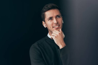 Yatay genç yakışıklı adam portresi kablosuz kulaklık konuşmak siyah arka plan üzerine, izole bir meslektaşı ile bir arama yok. Beyaz işadamı kablosuz kulaklık kullanarak.