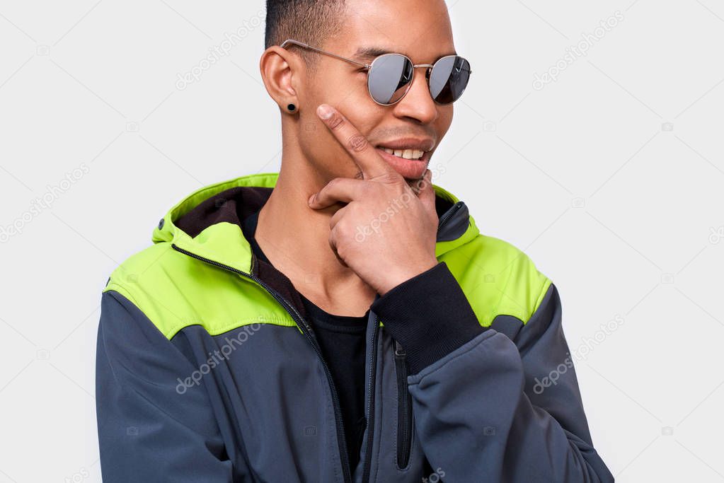 Closeup image of African American man smiling and posing for advertisement wears trendy mirror sunglasses, isolated on white wall with copy space for your text. People, emotion and lifestyle concept