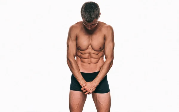 A kép vízszintes fitness férfi modell mutatja a hasi törzs, fehér alapon fekete fehérnemű. Egészséges erős sportos férfi szexi has jelentő stúdióban portré. Egészséges életmód — Stock Fotó