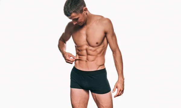白い背景の上の彼の腹部の胴体を示す黒の下着でフィットネスの男性モデルの水平方向の画像。健康な強い運動男セクシーな腹部のスタジオでポーズをとるします。健康的なライフ スタイル — ストック写真