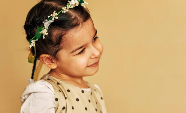 귀여운 작은 소녀, 그녀의 머리에 꽃과 함께 가족 사진을 위한 포즈. 행복 한 매력적인 아이 소녀 미소 빈 복사본 공간 긍정적인 감정. 사람과 감정 개념 — 스톡 사진