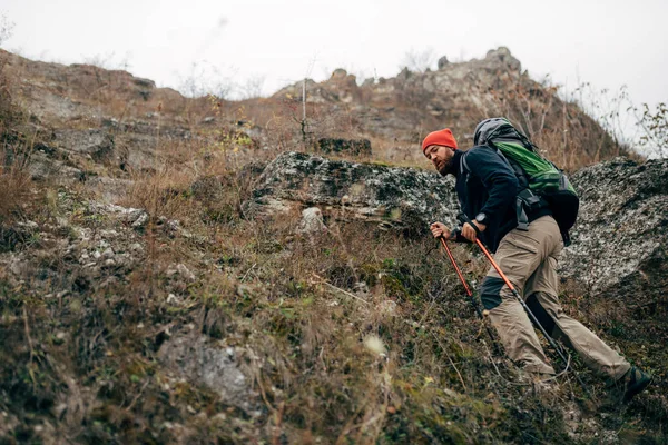 Jeune randonnée masculine active en montagne avec sac à dos de voyage. Voyageur barbu homme trekking et alpinisme au cours de son voyage. Voyage, personnes, sport et mode de vie sain concept — Photo