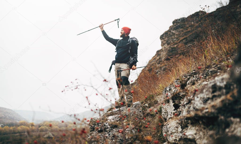 Tourist young male hiking in mountains, finished his track. Landscape view of traveler bearded man trekking and mountaineering during his journey. Travel, people, sport and healthy lifestyle concept