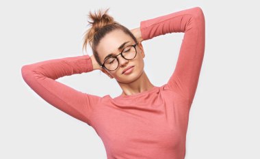 Avrupa neşeli genç kadın holding silah başında beyaz stüdyo arka plan üzerinde duran Kapalı gözlerle serbest zaman tadını çıkarın. Olumlu insan duyguları kavramı. 