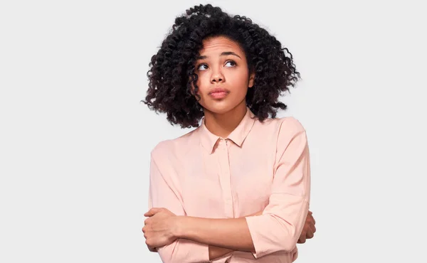 Mulher afro-americana cuidadosa tem expressão de pensamento, olhando para o espaço de cópia em branco. Mulher de pele escura duvidosa não pode fazer escolha, questionou a expressão, isolado no branco . — Fotografia de Stock