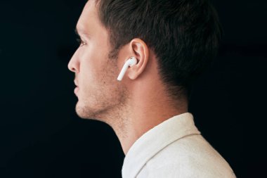 Portre yan görünüm beyaz stüdyo arka planda radyo earphones ile poz ciddi yakışıklı delikanlı. Kablosuz Kulaklık kullanarak beyaz iş adamı. İnsanlar, teknoloji ve iş kavramı