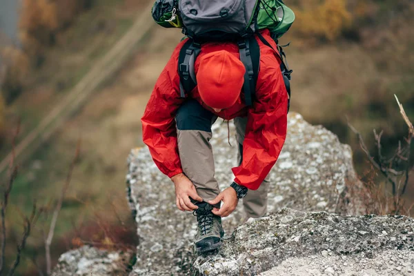 Caucasian young hiker man hiking in mountains dressed in red clothes exploring new places. Traveler bearded male trekking and mountaineering during his journey. Travel, people, sport, lifestyle